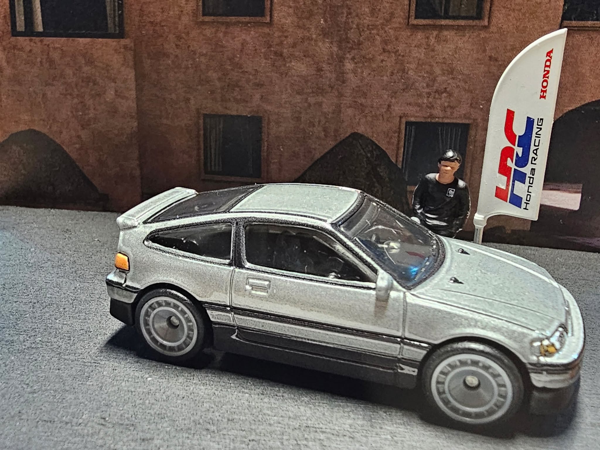 🩶 Lightweight legend. Timeless soul.

Ein silberner Blitz aus der Vergangenheit – der ’88 Honda CR-X aus der Japan Historics 5-Serie. Schlank, präzise, kompromisslos analog. Unter Neonlicht glänzt er wie frisch aus den Achtzigern, während das HRC-Flag im Wind zittert – ein Symbol für die goldene Honda-Ära.

Specs & Vibes:
Marke: Hot Wheels Car Culture – Japan Historics 5
Modell: 1988 Honda CR-X
Lackierung: Silver Metallic mit schwarzen Akzenten
Details: Realistische Head- & Taillights, Honda Badges, feine Trim Lines, California Plate “88CRX”
Szene: Urban Honda Meet mit Racing Heritage – purer Nippon-Stil in 1:64

Klein. Leicht. Legendär – der CR-X bleibt der Inbegriff von Fahrfreude.