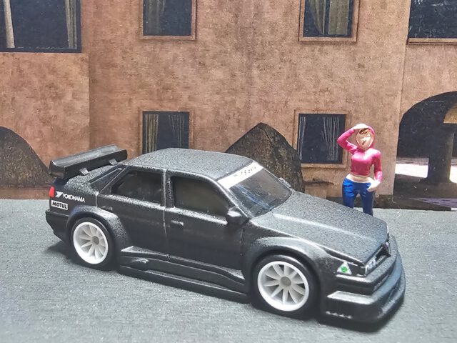 🖤 Italian fury. Touring soul.

Kein Lack glänzt, kein Chrom lenkt ab – nur pure Aggression in Mattschwarz. Der 1995 Alfa Romeo 155 V6 TI steht da wie ein Krieger aus der DTM-Ära: tief, breit, kompromisslos. Die weißen Felgen wirken wie Kampfnarben – Zeichen eines Renners, der nie für die Vitrine gebaut wurde.

Specs & Vibes:
Marke: Hot Wheels – Alfa Romeo Car Culture 2-Pack
Modell: Alfa Romeo 155 V6 TI (1995)
Lackierung: Matte Black Finish
Details: Detaillierte Head- & Taillights, Alfa Romeo & Motul Logos, Yokohama Branding, Quadrifoglio Emblem, feine Racing Trimlines
Szene: Street Light trifft Touring DNA – italienische Präzision im Maßstab 1:64

Mattschwarz. Lautlos. Alfa mit Adrenalin im Blut.