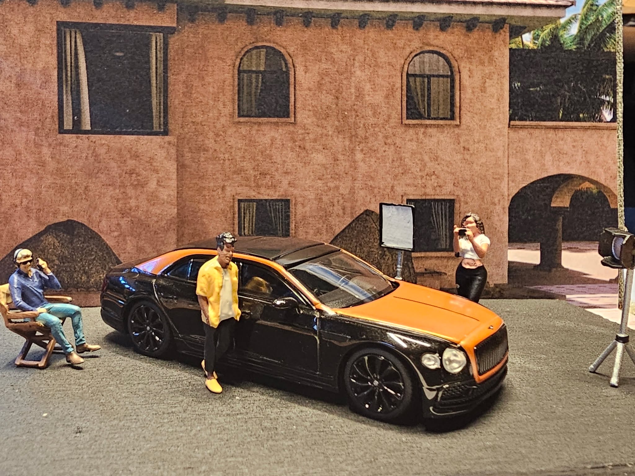 🧡🖤 Two-tone royalty. Kein Filter nötig.
Wenn Luxus lautlos ist, aber trotzdem den Raum übernimmt: Bentley Flying Spur in Orange Flame / Onyx. Vorne brennt die Farbe wie Studio-Licht, hinten schluckt das Schwarz jede Ablenkung. Und die Szene passt perfekt: Lampenstativ, Fotograf*in, Crew – als wäre das Ding nicht 1:64, sondern ein echter VIP-Shoot nach Mitternacht.
Specs & Vibes:
Hersteller: Mini GT (TSM Model)
Modell: Bentley Flying Spur
Lack: Orange Flame / Onyx (Two-Tone Boss Move)
Details: Detaillierte Headlights, sauberes Badging, feine Grill-Struktur, edle Linienführung
Shot-Mood: Filmset-Vibes – warmes Keylight, dunkle Shadows, pure Presence
Luxus flüstert. Bentley bestimmt.